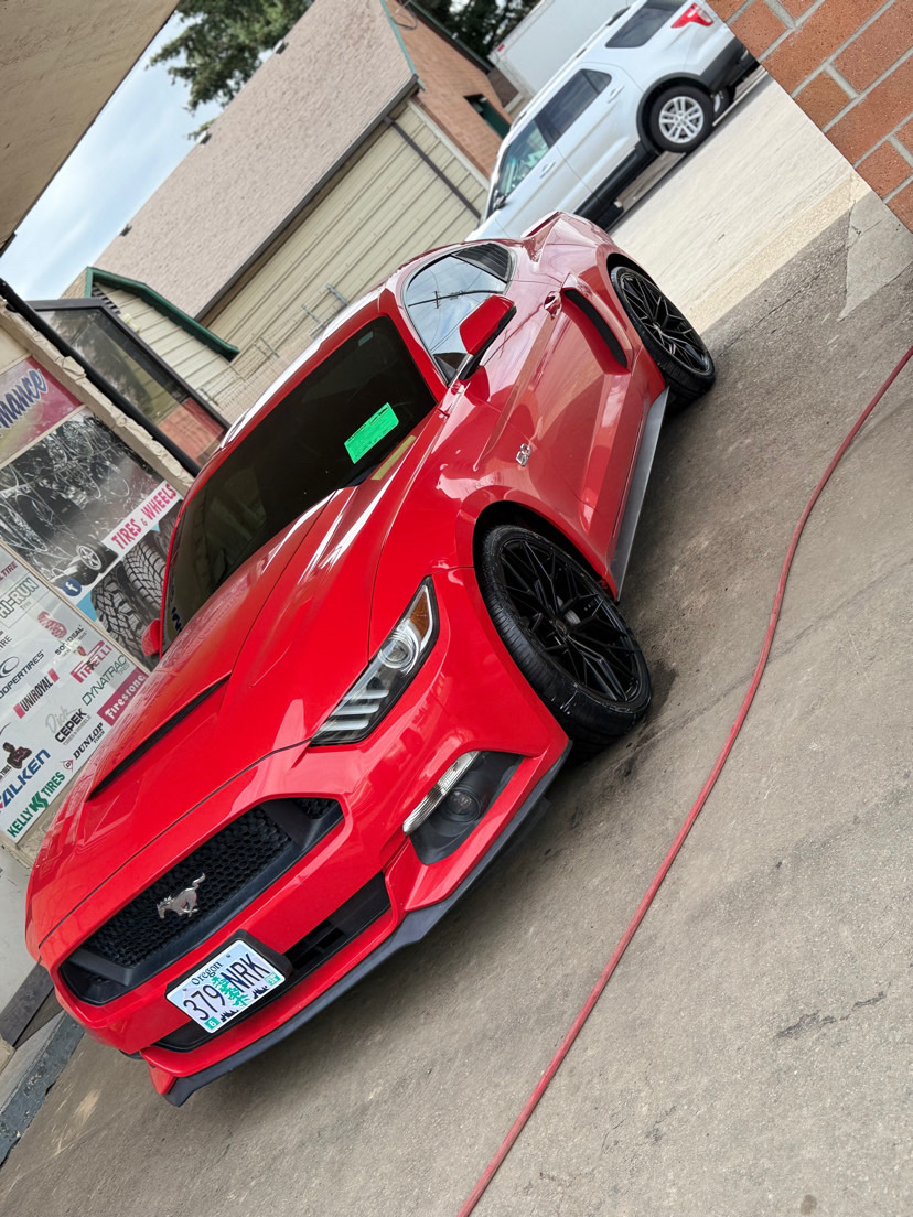 red Ford Mustang parked outside MC Wheels and Tires with upgraded black wheels