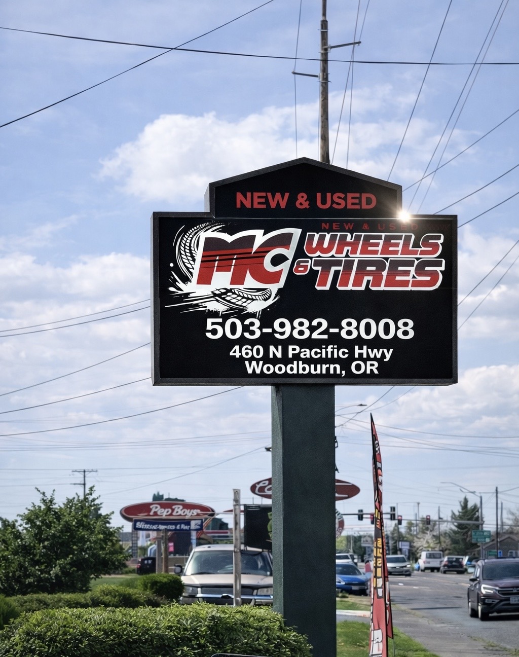 MC Wheels and Tires roadside sign with shop branding and contact information